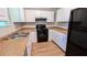 Efficient kitchen with white cabinets, laminate countertops, and black appliances at 1182 Demere Dr, Stone Mountain, GA 30083
