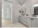 A modern bathroom features double sinks, sleek gray cabinets and a minimalist design at 1230 Mado Loop, Chattahoochee Hills, GA 30268