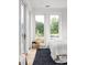 Bright bedroom with a bed and a dark rug, complemented by views of the neighborhood through the large windows at 1230 Mado Loop, Chattahoochee Hills, GA 30268