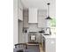 A stylish kitchen features gray cabinets, stainless steel appliances and a breakfast bar at 1230 Mado Loop, Chattahoochee Hills, GA 30268