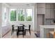 A stylish kitchen features light wood floors, lots of natural light, gray cabinets and breakfast nook at 1230 Mado Loop, Chattahoochee Hills, GA 30268