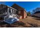 Brick home exterior showing the back porch with stairs and a hot tub on a lawn covered in leaves at 341 Little John Nw Dr, Lilburn, GA 30047