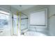 Bright bathroom with jacuzzi tub, glass enclosed shower, and large window at 341 Little John Nw Dr, Lilburn, GA 30047