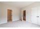 Neutral bedroom featuring plush carpet and convenient access to an en-suite bathroom with patterned tile floors at 4818 Floydwood Ln, Mableton, GA 30126