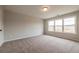 Light-filled bedroom with neutral carpet, large window offering pleasant views, and simple ceiling fixture at 4818 Floydwood Ln, Mableton, GA 30126