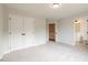 An empty bedroom with a double door closet and an open door to the on-suite bathroom at 4818 Floydwood Ln, Mableton, GA 30126