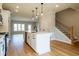 Open kitchen design with modern lighting fixtures, stainless steel appliances, white island and a view into an open living area at 4818 Floydwood Ln, Mableton, GA 30126