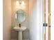 Stylish powder room boasts a pedestal sink, an oval mirror, and modern lighting at 4818 Floydwood Ln, Mableton, GA 30126