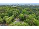 Aerial view showing a building surrounded by dense forest and greenery with buildings in the background at 1301 Cumberland Se Ct, Smyrna, GA 30080