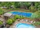 A shared swimming pool, tennis court, building and surrounding trees with lush landscaping at 1301 Cumberland Se Ct, Smyrna, GA 30080