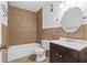 A cozy bathroom featuring a tub with tile surround, a modern vanity, and a round mirror at 1301 Cumberland Se Ct, Smyrna, GA 30080