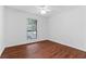 A bright bedroom with wood floors, white walls, a window, and a ceiling fan at 1301 Cumberland Se Ct, Smyrna, GA 30080