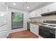 Bright kitchen features white cabinets, wood-look floors, granite countertops and stainless steel appliances at 1301 Cumberland Se Ct, Smyrna, GA 30080