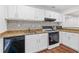 Kitchen boasts stainless appliances, granite counters, white cabinets and wood-look floors at 1301 Cumberland Se Ct, Smyrna, GA 30080