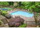 Relaxing in-ground swimming pool surrounded by lounge chairs, lush landscaping, and a tennis court at 1301 Cumberland Se Ct, Smyrna, GA 30080