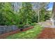Private backyard featuring lush greenery, a wood fence and a cozy patio area at 2319 Alnwick Dr, Duluth, GA 30096