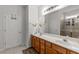 Bright bathroom featuring double sinks, a large mirror, and a shower with glass doors at 2319 Alnwick Dr, Duluth, GA 30096