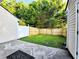 A wood fence surrounds the backyard with green grass and some trees in the background at 2430 Piering Dr, Lithonia, GA 30038