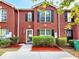 Charming brick townhome with black shutters, well-manicured bushes, and mulch at 2430 Piering Dr, Lithonia, GA 30038