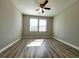 Bright bedroom with wood-look flooring, a ceiling fan, and natural light streaming in through windows at 2526 Piering Dr, Lithonia, GA 30038