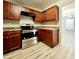 Modern kitchen with stainless steel appliances, wood-tone cabinets, and sleek laminate flooring at 2526 Piering Dr, Lithonia, GA 30038