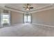Spacious bedroom featuring large windows with curtains and a tray ceiling at 3910 Cameron Ct, Cumming, GA 30040