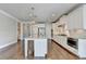 Open kitchen with white cabinetry, granite countertops, and hardwood floors at 3910 Cameron Ct, Cumming, GA 30040