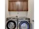 Laundry room with front-load washer and dryer and upper cabinets for storage at 3910 Cameron Ct, Cumming, GA 30040