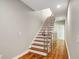Hallway featuring hardwood floors and wood staircase with stainless steel rails at 472 Martin Se St # 10, Atlanta, GA 30312