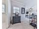 Bedroom view showcasing a dresser, framed artwork, carpeted floors, and a glimpse into the connected living space at 5605 Waters Edge Trl, Roswell, GA 30075