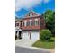 Charming brick townhouse with a two-car garage, black shutters, and well-maintained landscaping at 5605 Waters Edge Trl, Roswell, GA 30075