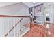 Hallway with wood floors, staircase with white railings and built-in shelving unit at 5605 Waters Edge Trl, Roswell, GA 30075