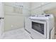 Bright laundry room featuring a modern, white front-loading washer and dryer, and wire shelving for storage at 5605 Waters Edge Trl, Roswell, GA 30075