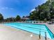 Large community pool with plenty of lounge chairs, surrounded by mature trees and well-manicured landscaping at 5605 Waters Edge Trl, Roswell, GA 30075