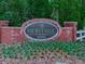 Elegant brick entrance sign for Heritage at Roswell with well-maintained landscaping and colorful flowers at 5605 Waters Edge Trl, Roswell, GA 30075