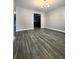 Open-concept living space with hardwood flooring and contemporary chandelier at 2533 Piering Dr, Lithonia, GA 30038