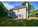 A home's back exterior shows a spacious lawn and a stone patio with a door to go inside the house at 2687 Mountain Oaks Ct, Powder Springs, GA 30127