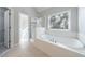 Bright bathroom featuring a soaking tub and a glass-enclosed shower, illuminated by natural light from the window at 2687 Mountain Oaks Ct, Powder Springs, GA 30127