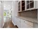 Butler pantry with granite countertops, stylish tile backsplash, glass cabinets, and hardwood floors at 2687 Mountain Oaks Ct, Powder Springs, GA 30127