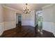 Dining room featuring hardwood floors, wainscoting, a chandelier, and an open view to other rooms at 2687 Mountain Oaks Ct, Powder Springs, GA 30127