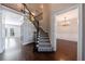 Elegant foyer showcasing a staircase with wrought iron railings and dark hardwood flooring at 2687 Mountain Oaks Ct, Powder Springs, GA 30127