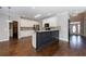 Open kitchen with stainless steel appliances, white cabinets, dark island, and hardwood floors at 2687 Mountain Oaks Ct, Powder Springs, GA 30127