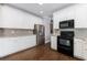 Kitchen featuring white cabinets, stainless steel refrigerator, and black oven range at 2687 Mountain Oaks Ct, Powder Springs, GA 30127