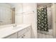 Bathroom features a single sink vanity with white cabinets and a tub and shower combo with a leafy curtain at 725 Windsor Place Sw Cir, Grayson, GA 30017