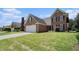 Brick home with large lawn, two car garage, and manicured landscaping at 725 Windsor Place Sw Cir, Grayson, GA 30017