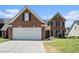 Charming brick home showcasing a well-maintained lawn, two car garage, and classic architectural details at 725 Windsor Place Sw Cir, Grayson, GA 30017