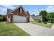 A wide driveway leads to the brick home with an attached two-car garage, complemented by verdant landscaping at 725 Windsor Place Sw Cir, Grayson, GA 30017