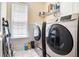 Functional laundry room with modern appliances and storage shelves, making laundry tasks easy at 725 Windsor Place Sw Cir, Grayson, GA 30017