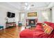 Comfortable living room with a stone fireplace, hardwood floors, and tray ceiling, creating a cozy ambiance at 725 Windsor Place Sw Cir, Grayson, GA 30017