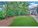 Well-manicured backyard showing lush greenery and a patio space adjacent to the house at 328 Broadmoor Way, Mcdonough, GA 30253